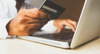 A man making an online payment using a credit card and laptop